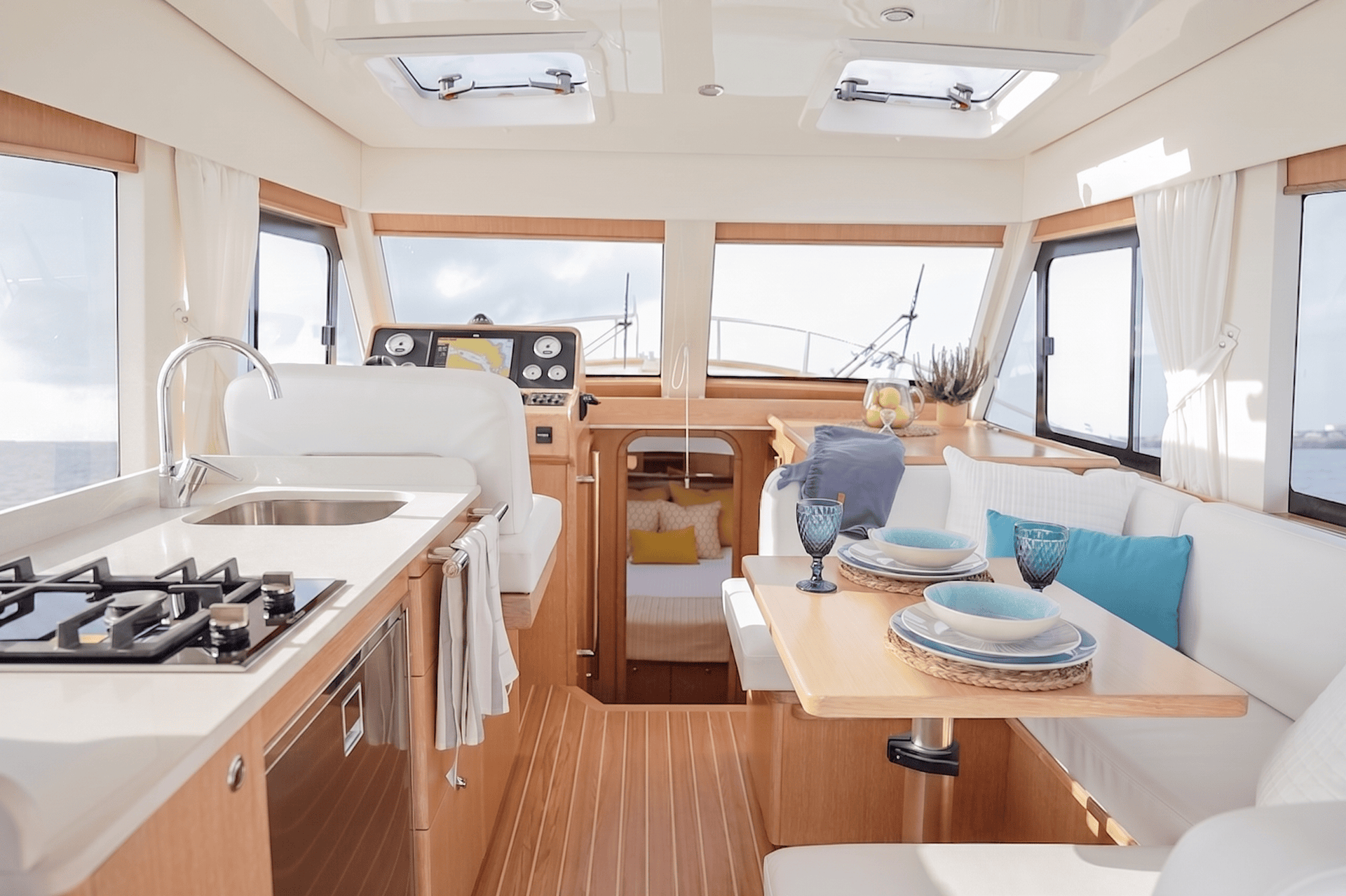 Salón y cocina del Menorquín 35 HT con grandes ventanas, dinette y puesto de gobierno