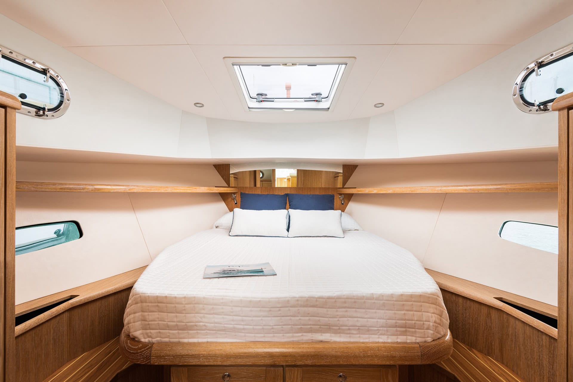 Camarote principal del Menorquín 35 HT con cama doble, portillos laterales y escotilla superior