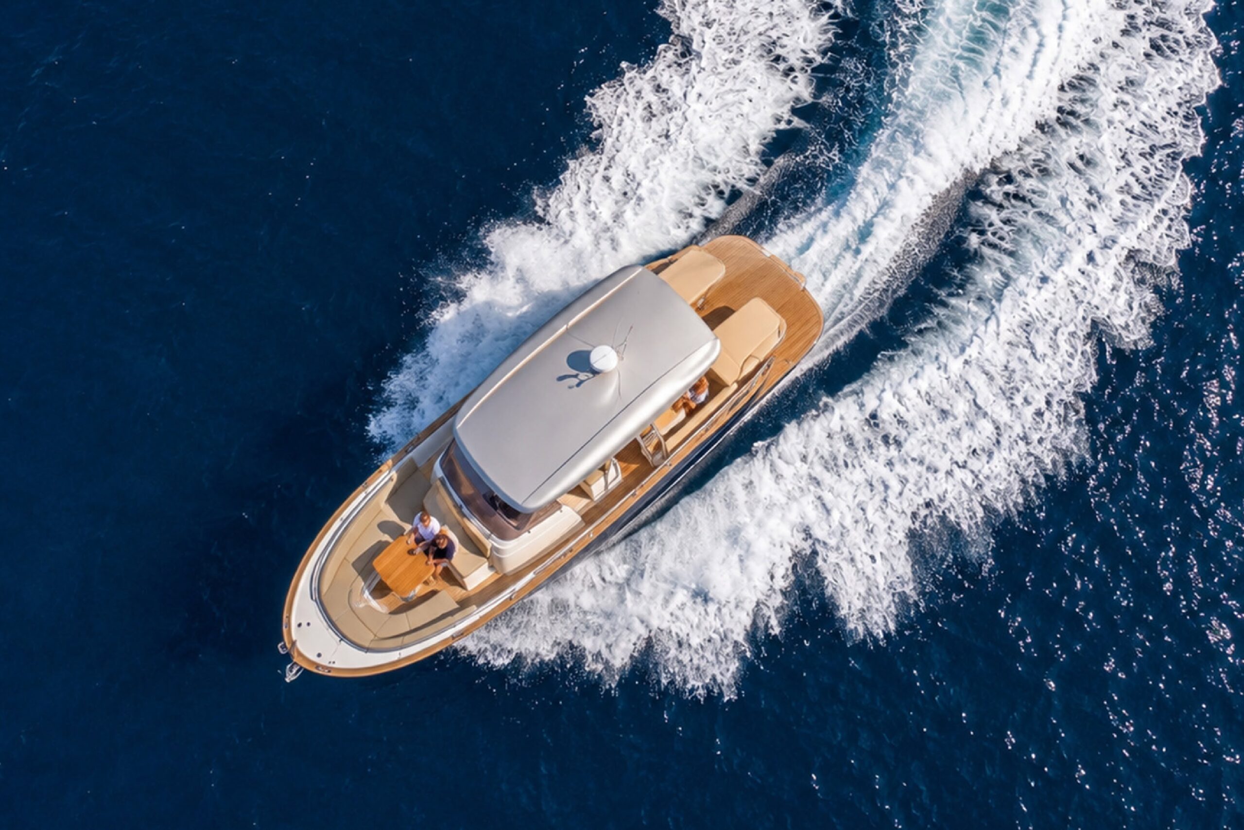 Menorquín 36 Open de Sasga Yachts navegando por el Mediterráneo, visto desde el aire con dos pasajeros en la zona de proa.