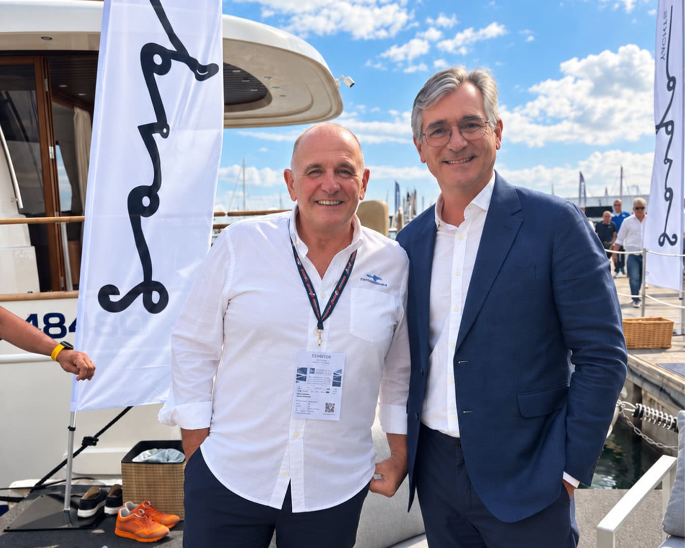 Jose Luis Sastre y Pedetti posan junto a las banderas de Sasga Yachts y un Menorquín en el Salón Náutico de Génova 2026.