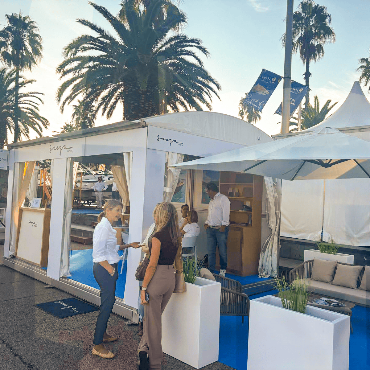 Visitantes conversando junto al stand de Sasga Yachts durante el Salón Náutico de Barcelona 2026, celebrado en el Port Vell.